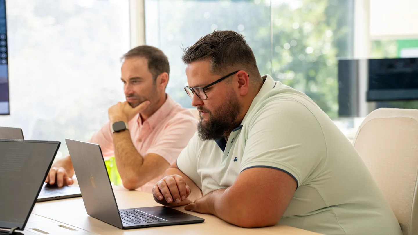 Two Gamache Média team members working on computers in their offices.